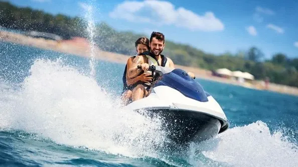 Feel the exhilaration as you speed across the sparkling waves on a jet ski.